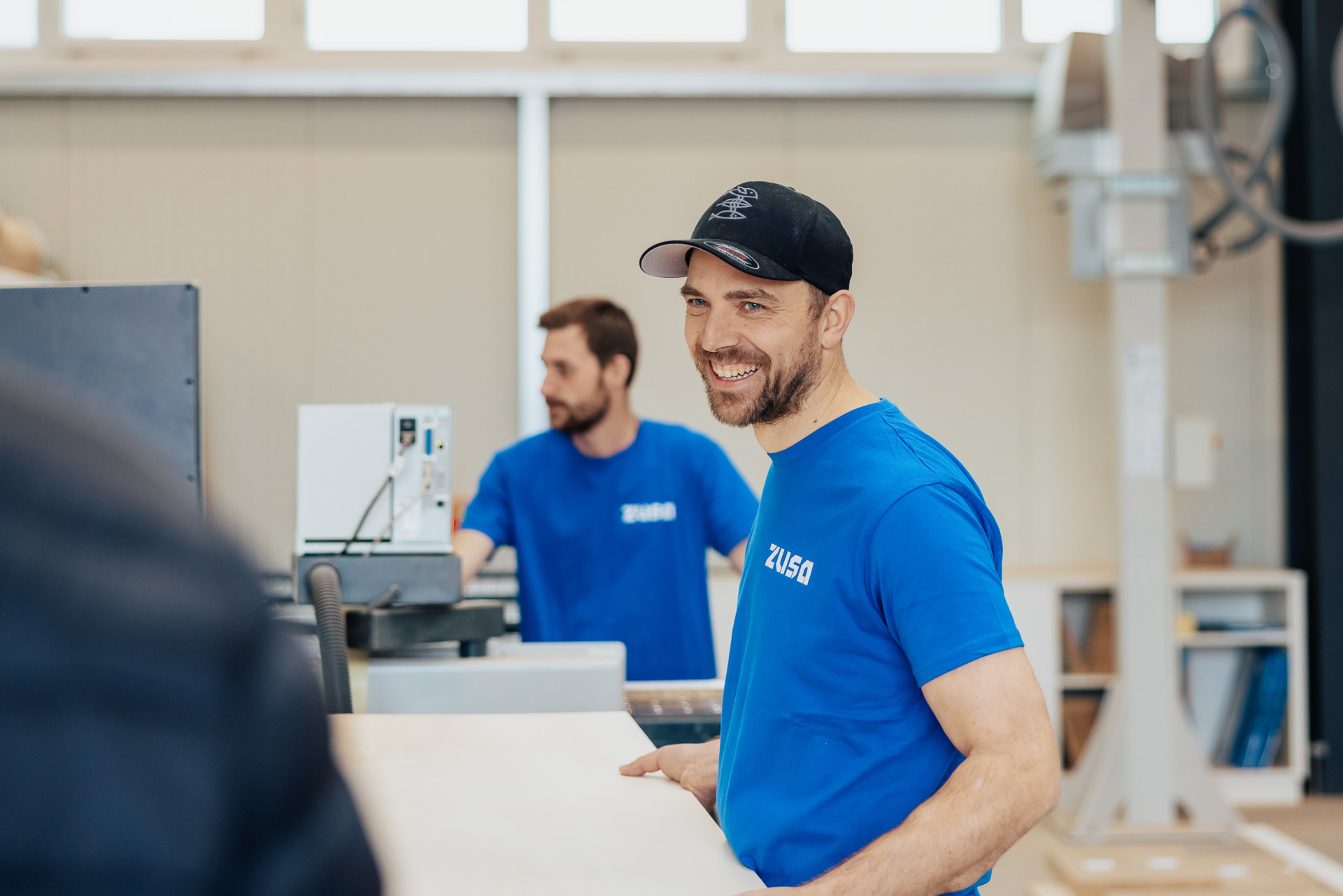 Zwei Männer in blauen T-Shirts mit dem Logo 